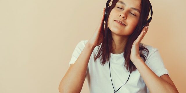 woman listening to music through headphones workplace mental health