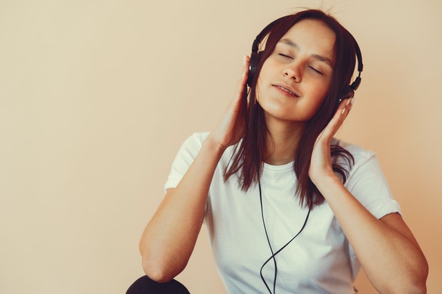 woman listening to music through headphones workplace mental health