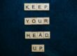 Scrabble pieces spelling out keep your head up for performance improvement plans