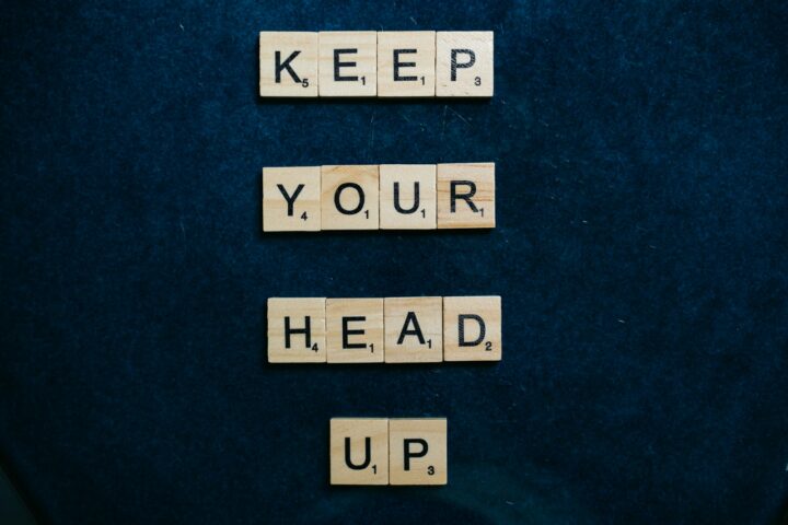 Scrabble pieces spelling out keep your head up for performance improvement plans