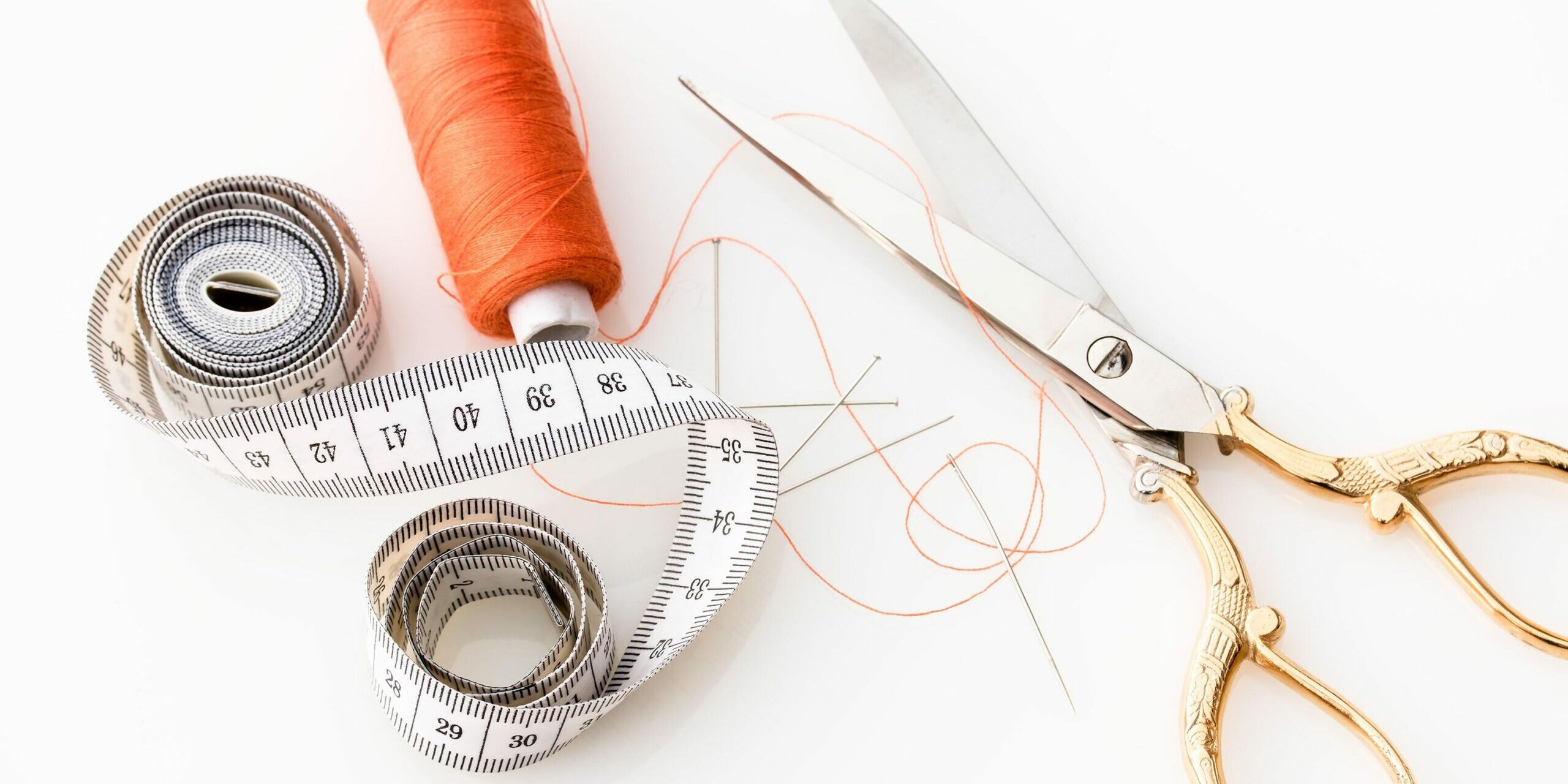 thread, scissors, and measuring tape on white background - tailor your resume to job description