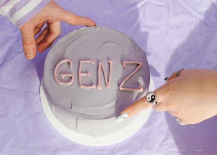 hands on light purple cake that says "gen z" - gen z in the workplace