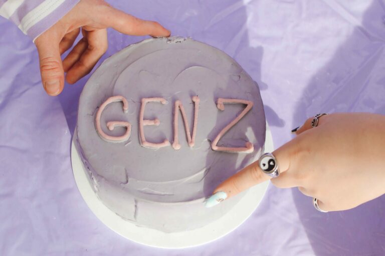 hands on light purple cake that says "gen z" - gen z in the workplace