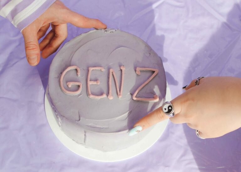hands on light purple cake that says "gen z" - gen z in the workplace