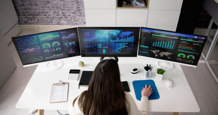 how to hire a data scientist woman data scientist sitting at a computer with three screens of data