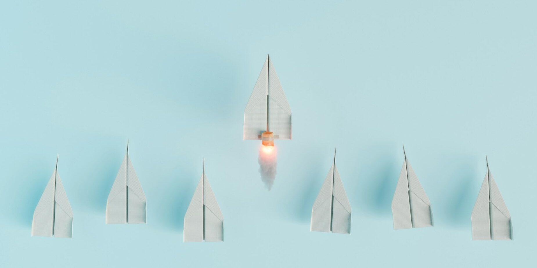 paper airplanes in a line with one taking off to symbolize leadership
