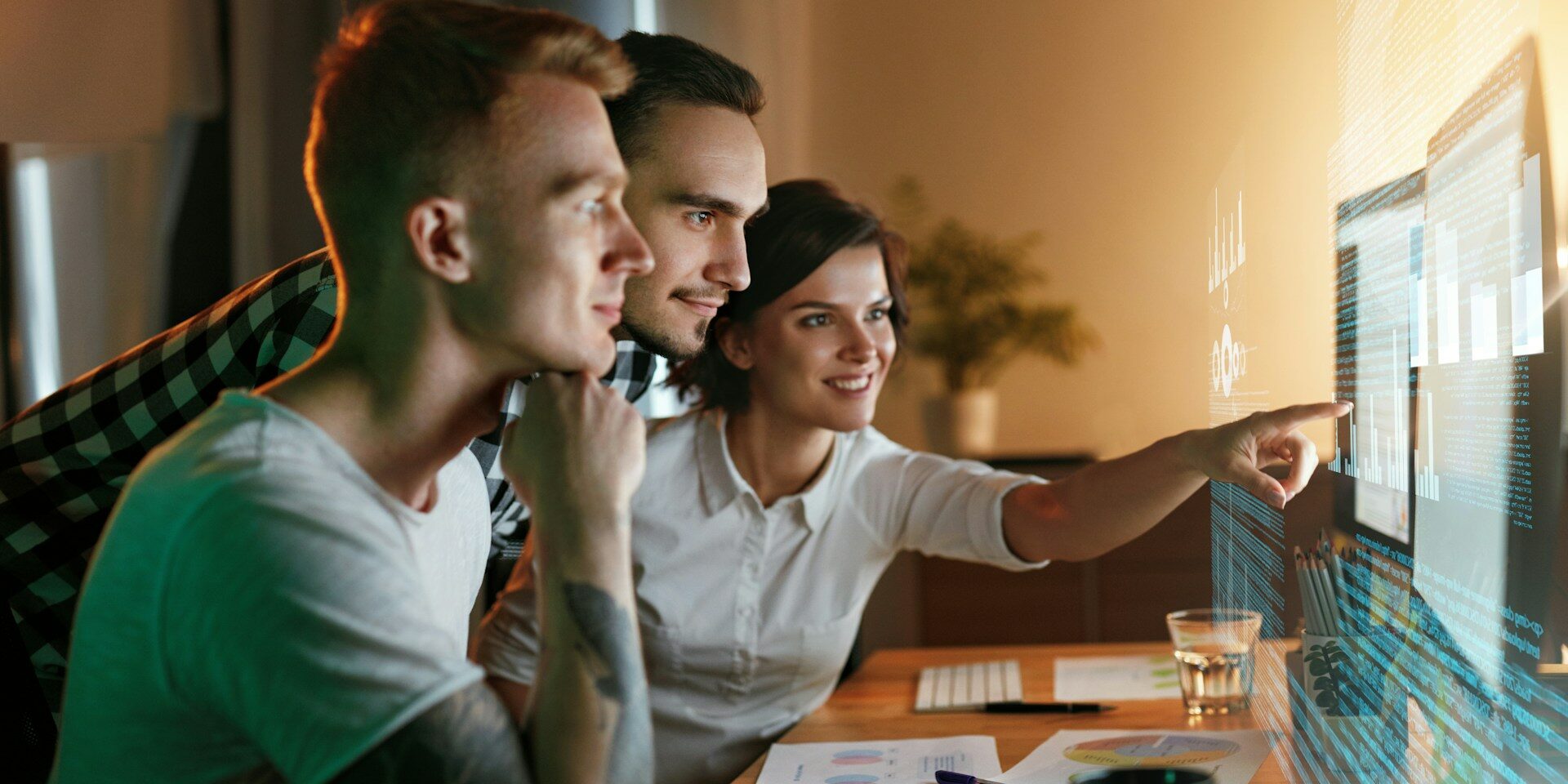 AI literacy in the workplace and why it is the business advantage a group of employees at a computer with a futuristic screen depicting an AI literate team