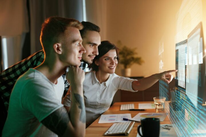 a group of employees at a computer with a futuristic screen depicting an AI literate team