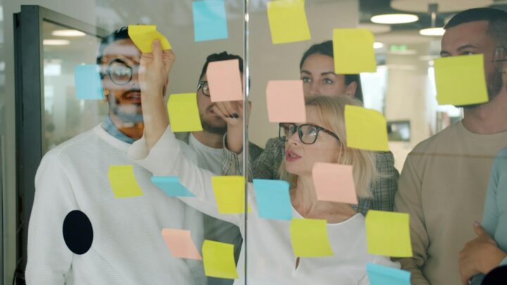 Marketing team brainstorming with sticky notes to design workflow and team structure